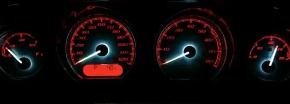 Red and blue LED illuminated Harley gauge cluster at night
